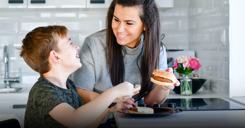mama e hijo compartiendo una hamburguesa